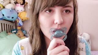 Violet playing with her blue pacifier