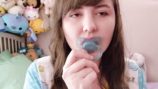 Violet playing with her blue pacifier