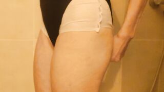 A girl is pooping in her diaper under swimsuit then take a shower.